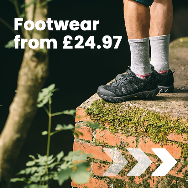A close-up of outdoor walking shoes on a moss-covered brick structure, promoting Peter Storm footwear from £24.97.