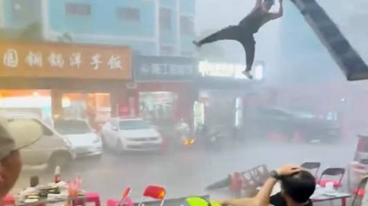 Iedereen vlucht tijdens plotse storm, maar deze slimmerik houdt de luifel vast