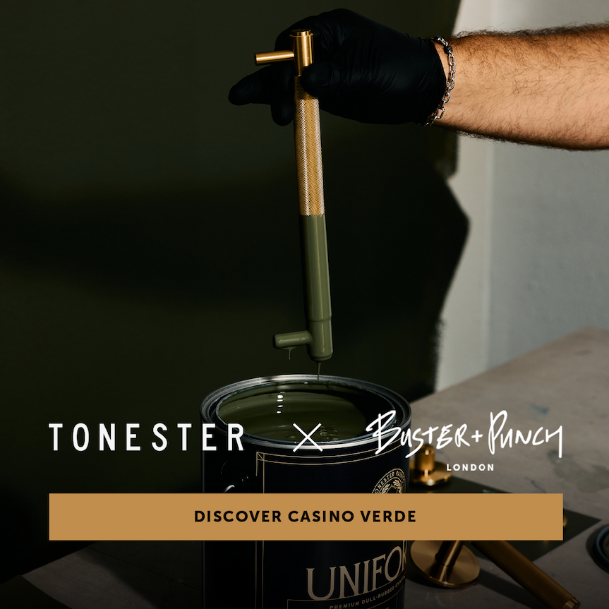 brass pull bar being dipped in green paint