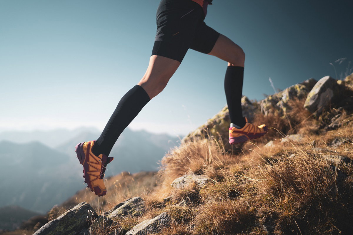 Un homme fait du trail avec des chaussettes de compression