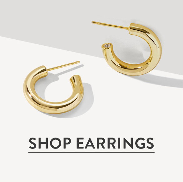 Shop earrings. Gold hoop earrings on a neutral background.