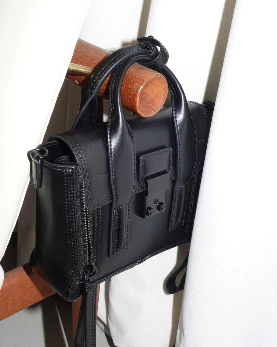 an image of two black bags on a stand on a white surface