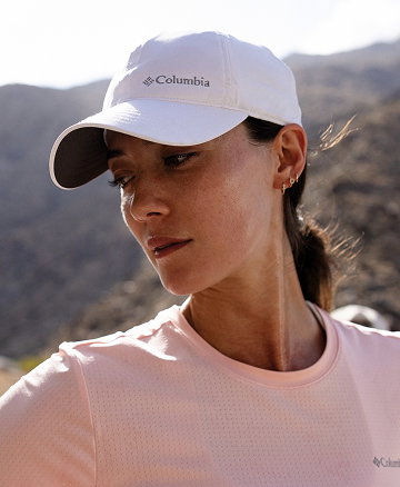 Woman wearing ball cap in a mountainous environment.