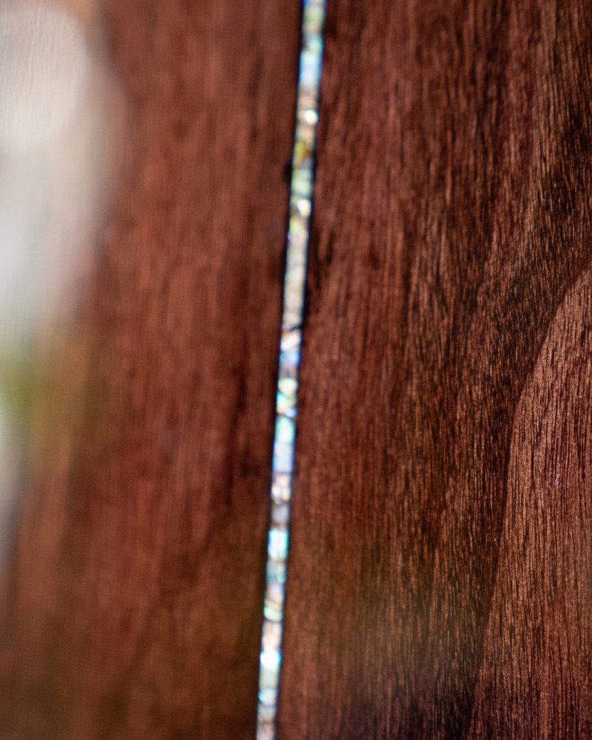Closeup of mahogany wood and abalone details
