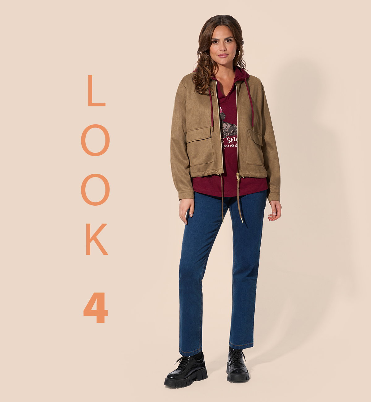 Frauenmodel trägt Jacke in Beige, dunkelrotes Oberteil, blaue Hose, schwarze Schuhe, Vorderansicht