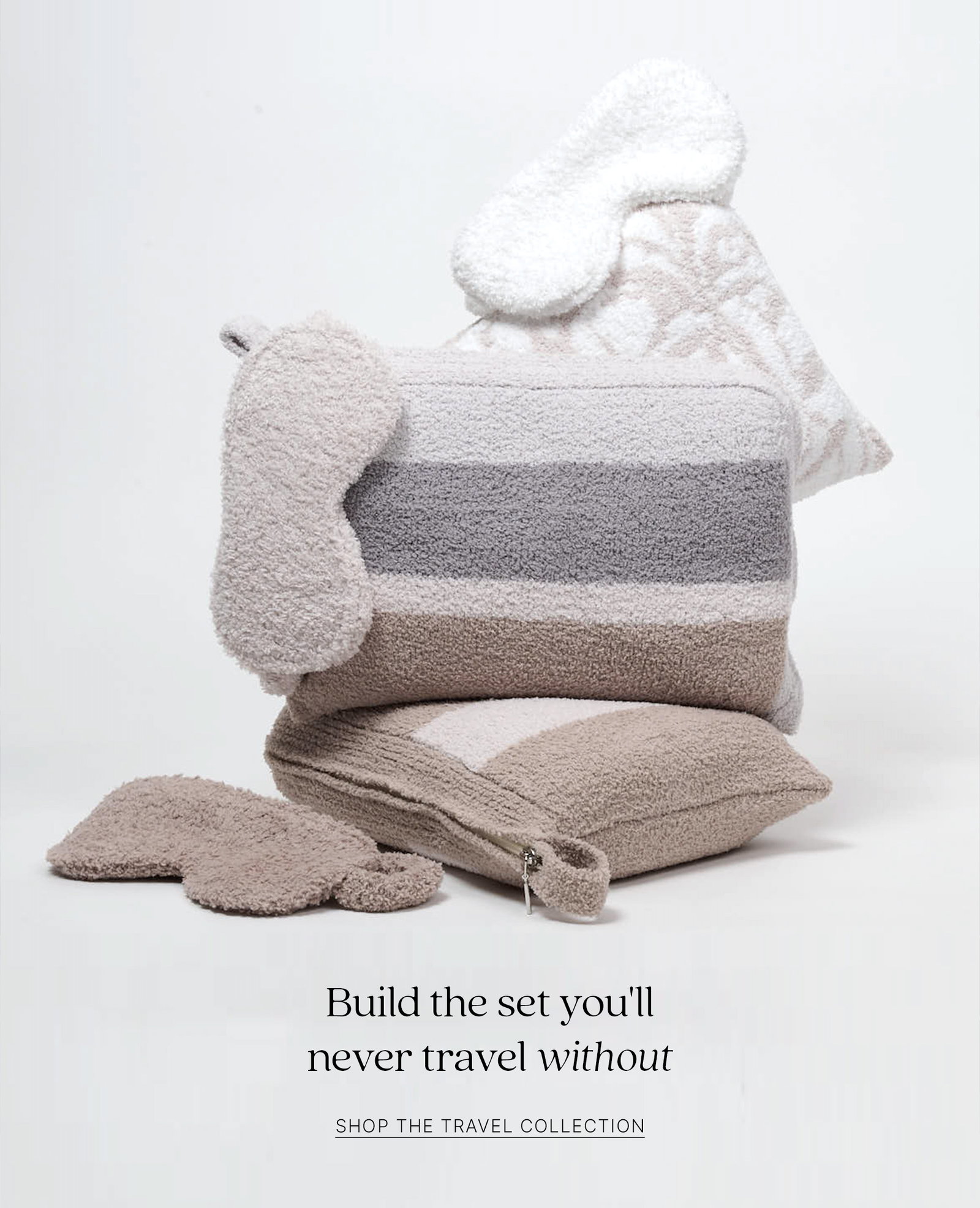 Assorted Kashwére travel essentials, including a striped travel pouch, travel blanket, eye masks, socks, and travel pillow. Build the set you'll never travel without.