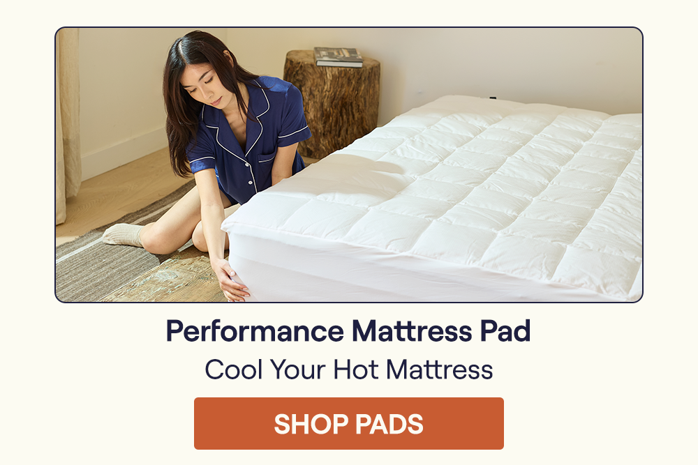 Woman placing a Performance Mattress Pad on a mattress