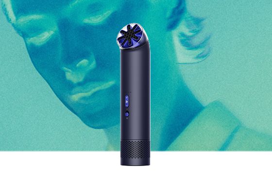 Dyson HushJet Mini Cool fan in Ink/Cobalt next to a model.