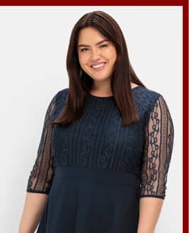 Ein Model trägt ein nachtblaues Cocktailkleid mit Spitze.