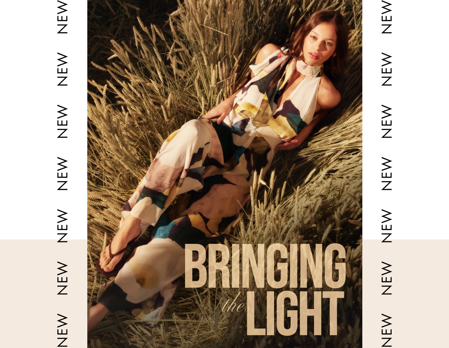 Model wearing a multicolour abstract print halterneck jumpsuit, relaxing in a golden wheat field