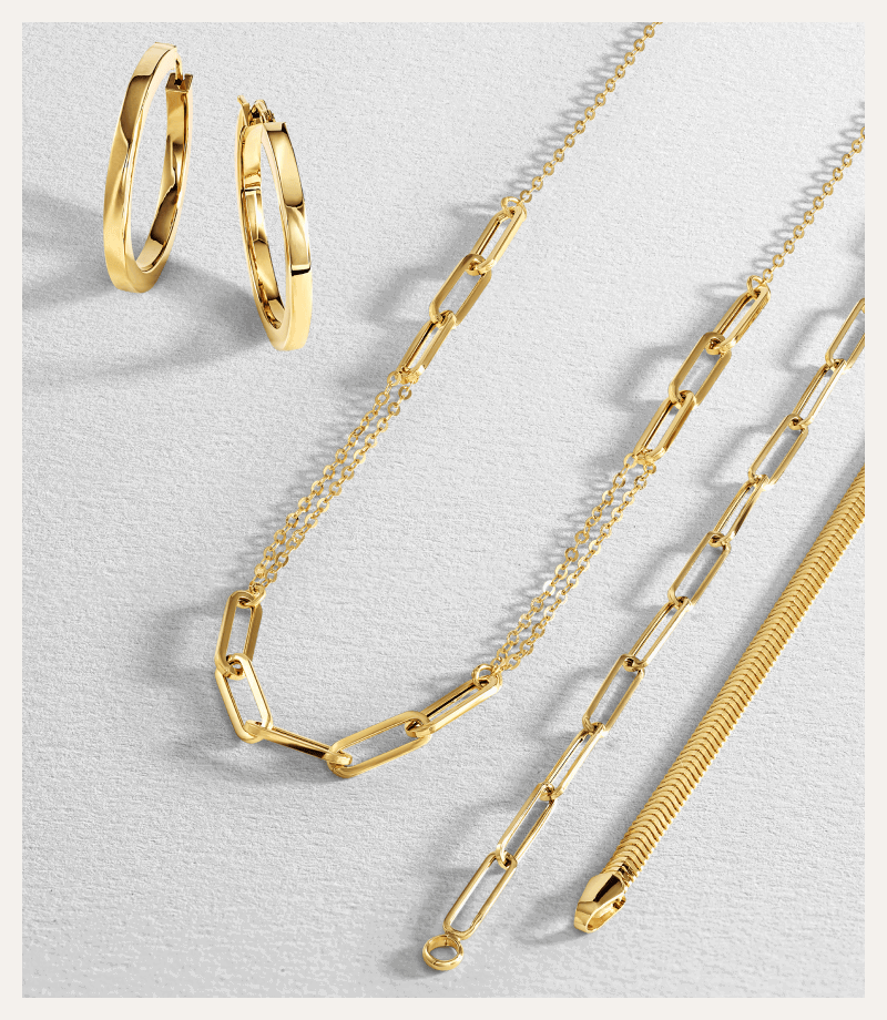 Yellow gold jewellery, featuring sleek hoops, paperclip chains and a herringbone chain necklace.