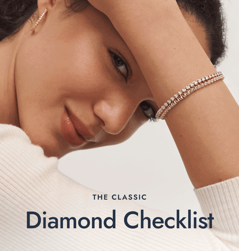 Woman wearing a white gold and yellow gold tennis bracelet and hoops. The classic diamond checklist.