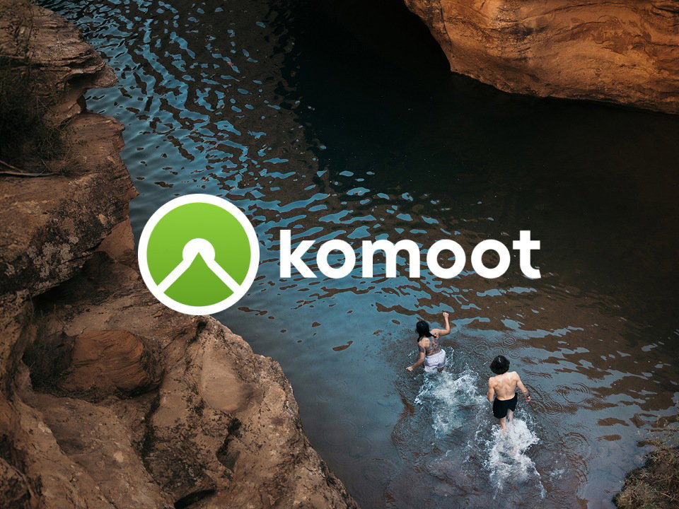 Image of two people in a river, with Komoot logo overlay.