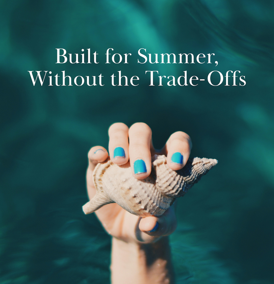 A hand with blue-painted nails holds a seashell above turquoise water. White text reads, "Built for Summer, Without the Trade-Offs.