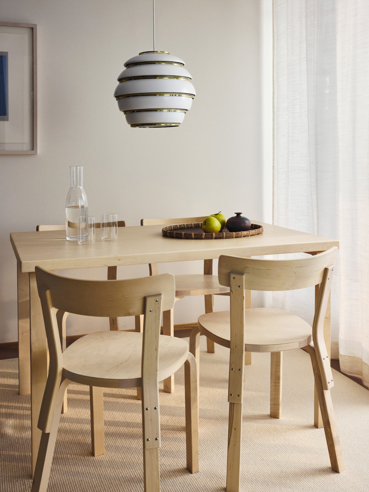 Lampada a sospensione Artek Beehive sopra un tavolo da pranzo in betulla