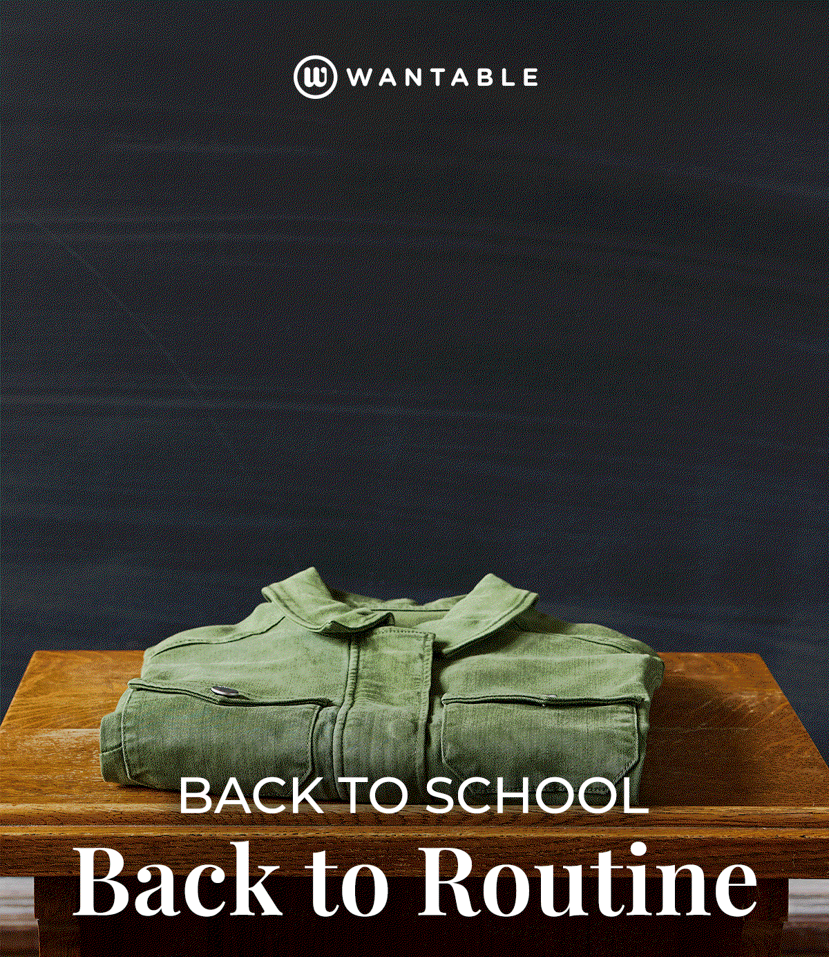 Stack of folded sweaters, jeans, and tops on a wooden bench for back to school.
