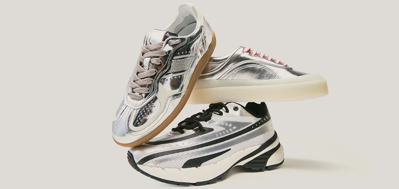 Trois paires de baskets empilées : tige argent métallique, surfaces texturées, accents contrastés en noir et blanc, différentes couleurs et styles de lacets.