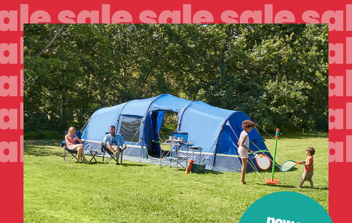 Two people sit in folding chairs near the tent while two children play a lawn game in front. Camping furniture and equipment are arranged outside the tent. The image is framed by a bright red border featuring repeated pale pink “sale” text, with a teal circular graphic partially visible in the bottom-right corner.