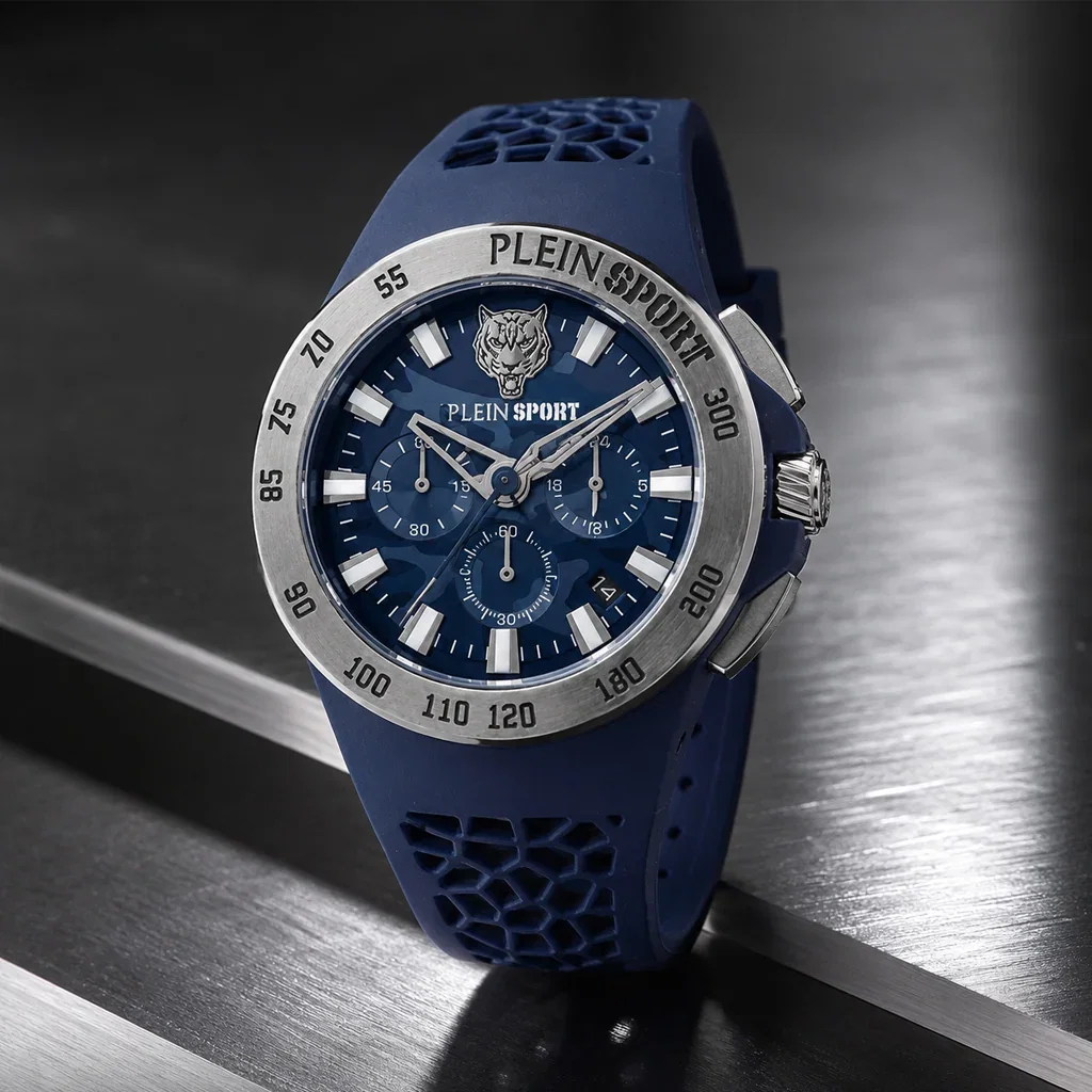 Plein Sport chronograph watch with dark blue dial, silver bezel, and matching rubber strap on metallic surface.