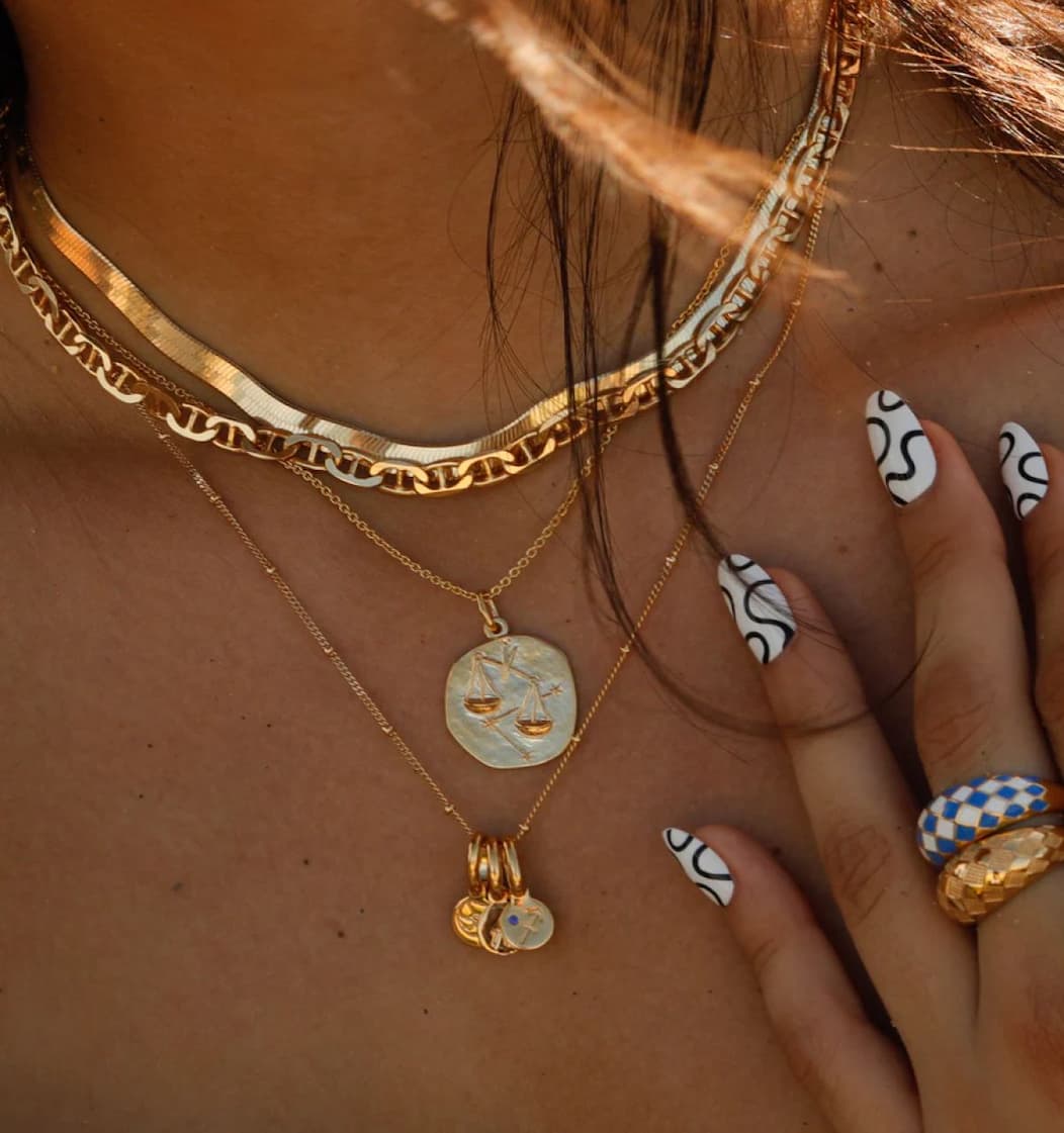 Woman wearing a stack of Rellery chain necklaces