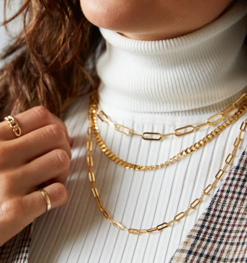 Woman in professional clothing wearing a chain necklace stack