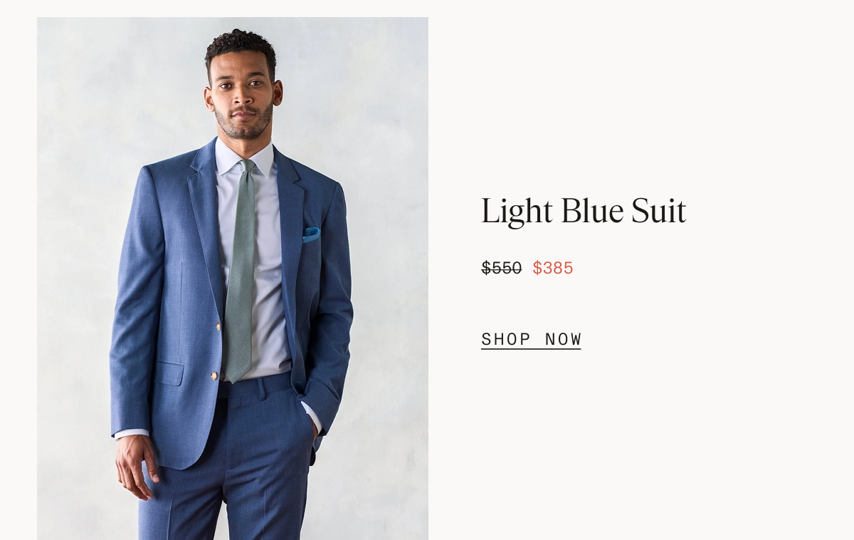 Split layout with a man with curly hair and a beard wearing a light blue suit, light blue shirt, and sage green tie with one hand in his pocket on the left, and text on the right reading: Light Blue Suit $550 $385 SHOP NOW