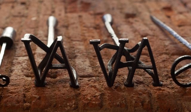 Livestock brand irons laying in a row on a wooden table