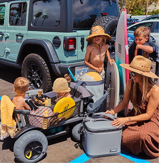 Family loading beach toys and gear into a Cruiser with a cargo net beside an SUV