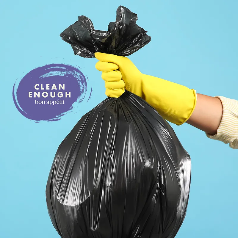 Image of hand with rubber glove lifting a trash bag out of a trash bin