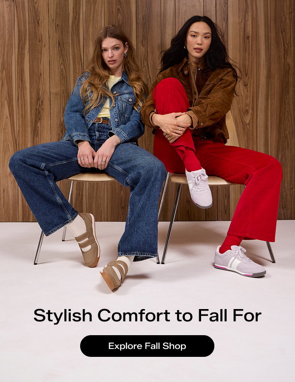 Two women seated on chairs against a wood‑paneled background wearing stylish, layered fall outfits. The woman on the left is wearing the Revival Mary Jane in mocha and the woman on the right is wearing the Revival Suede Lace-Up in lavender. Text on the image says Stylish Comfort to Fall. Explore Fall Shop.