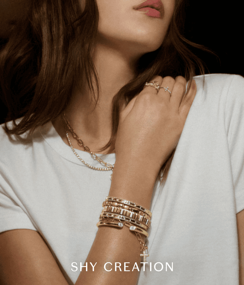 Model wearing layered gold jewelry.