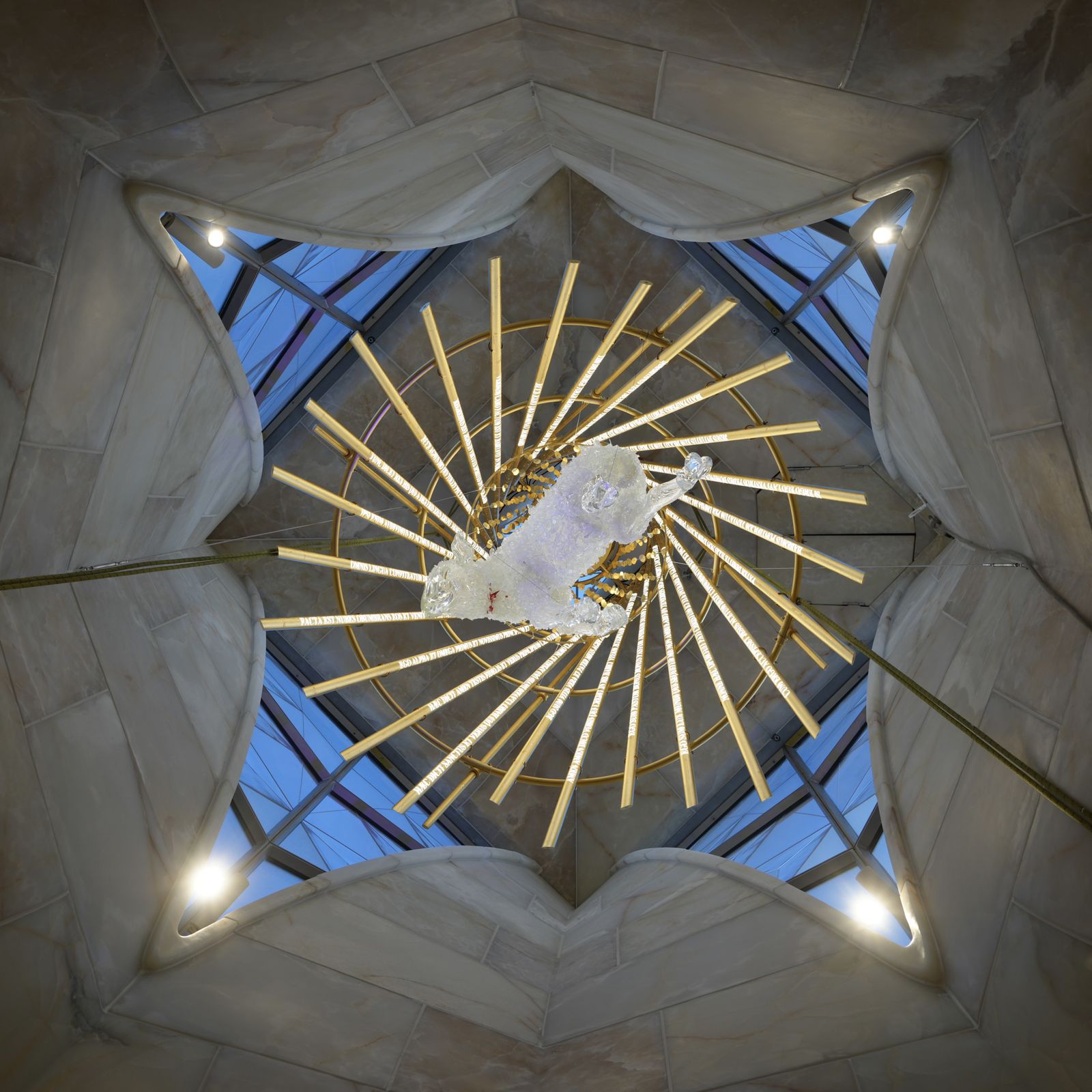 Lamp sculpture suspended in Sagrada Familia with light installation above it