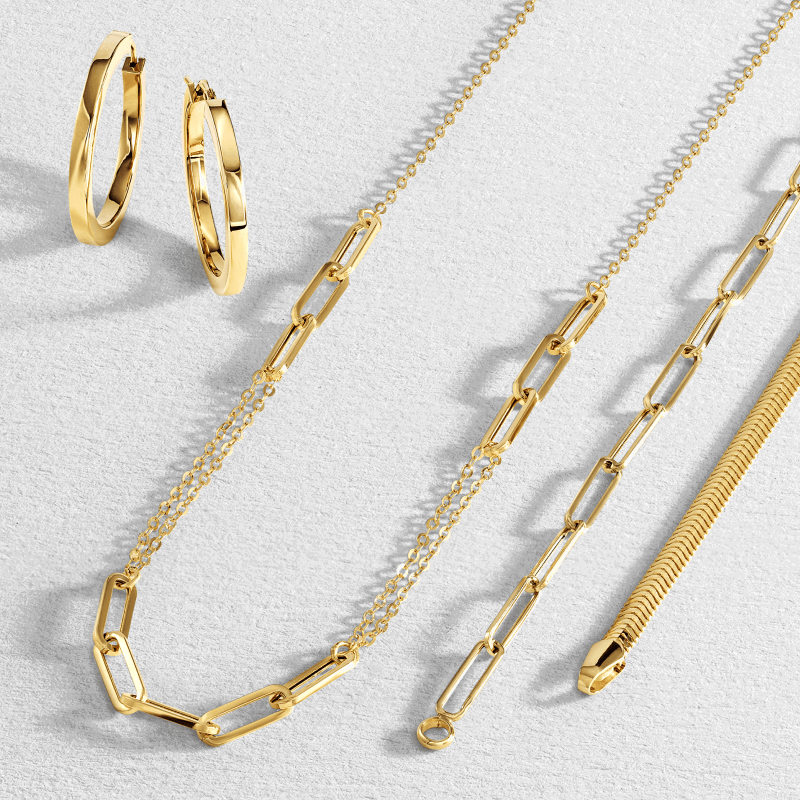 Yellow gold jewellery, featuring sleek hoops, paperclip chains and a herringbone chain necklace.