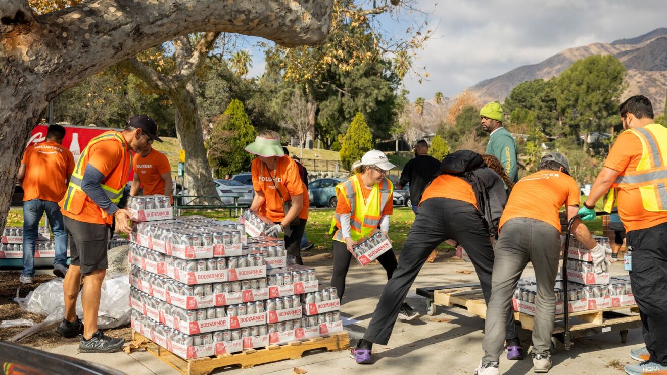 Community volunteers unload and organize packaged sports drinks