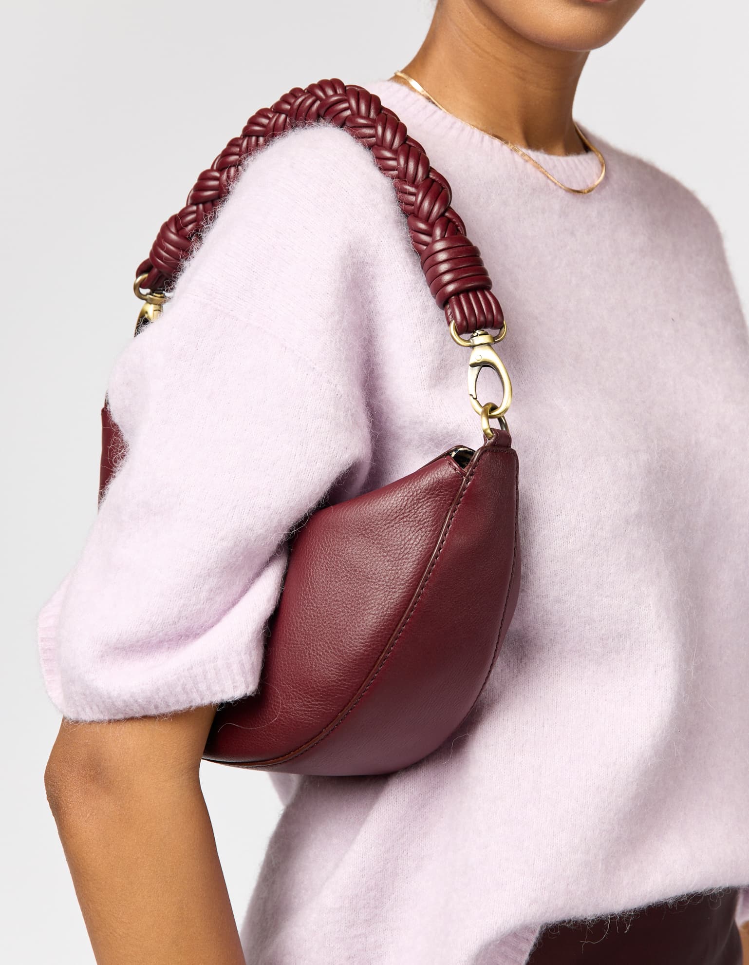 Model wearing Leo Twisted bag in color Dark Cherry