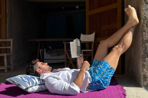 Man lounging in Linen Shirt and Swim trunks