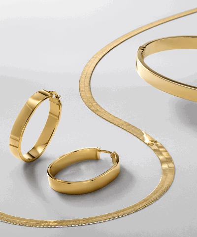 Yellow gold jewelry featuring a herringbone necklace, hoop earrings, stackable rings and a textured band.