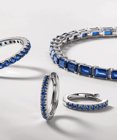 Blue gemstone tennis bracelets, hoop earrings and rings in white gold with diamond accents.