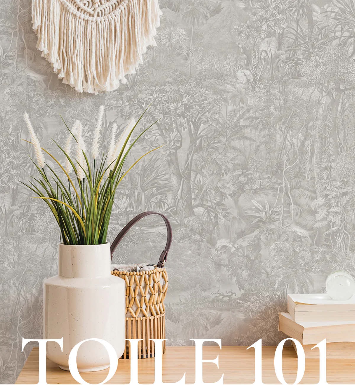 Image of Tempaper's Forest Toile wallpaper in moss green behind a table with books and a vase with with greenery. Text overlayed "Toile 101"