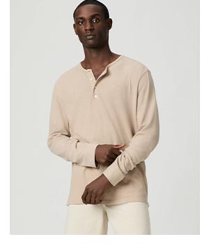 Image of a man wearing a beige long sleeve linen henley.