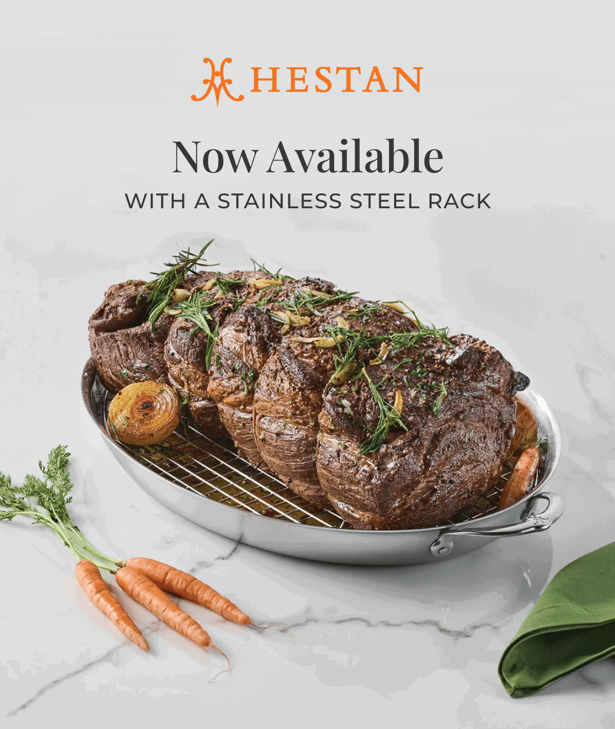 IMG: Cooked meat in Hestan Large Oval Roaster with Rack. Text that reads: "Now Available with a Stainless Steel Rack". Hestan logo at the top.