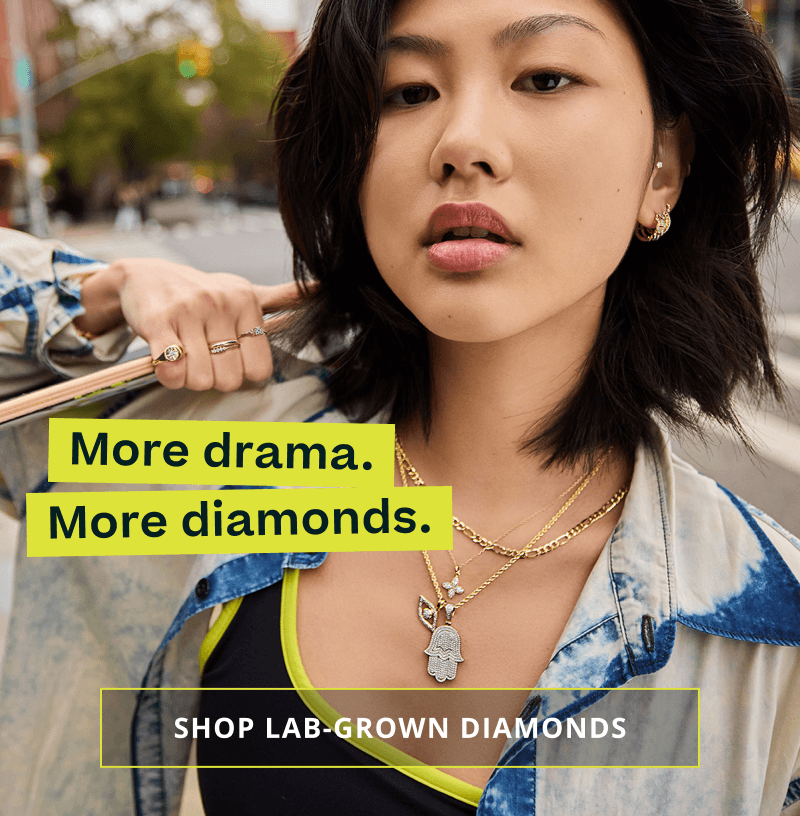 Model wearing thick gold layers with diamond pendants. More drama & diamonds. Click here to shop lab grown diamonds