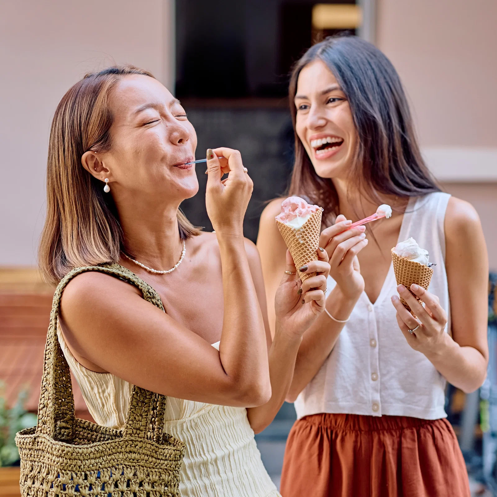 International FriendShip Day: two women laughing joyfully, enjoying an ice cream together