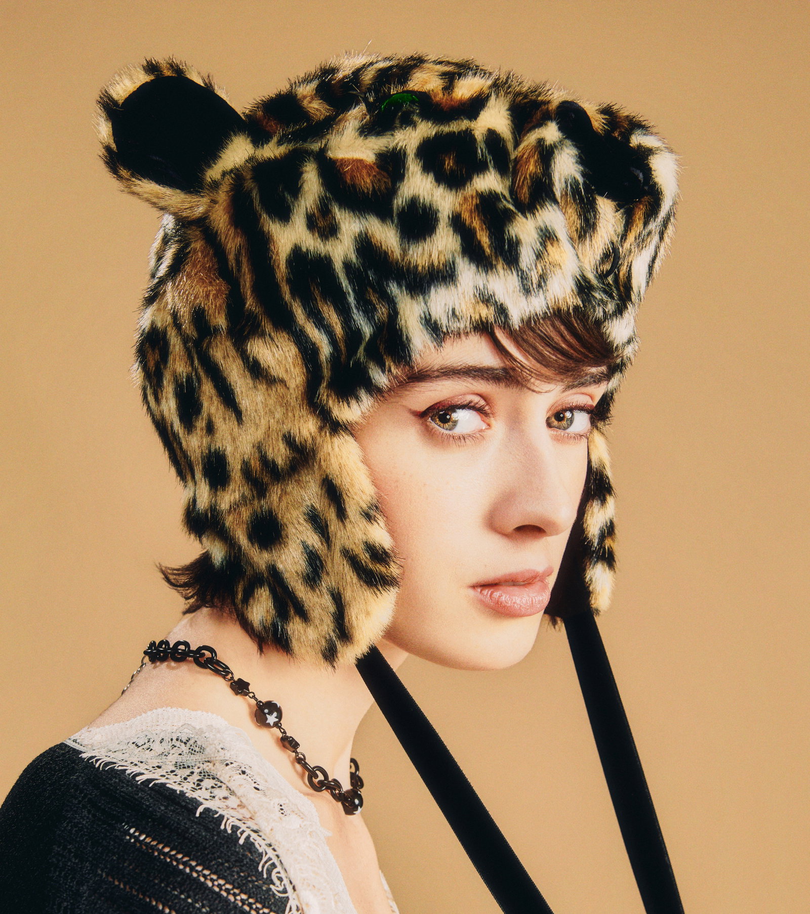 girl wearing hat that looks like a leopard head.