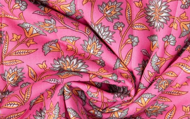 a pink and orange floral print fabricTissu Coton Matelassé réversible Santal fleuris sur fond Rose fuchsia