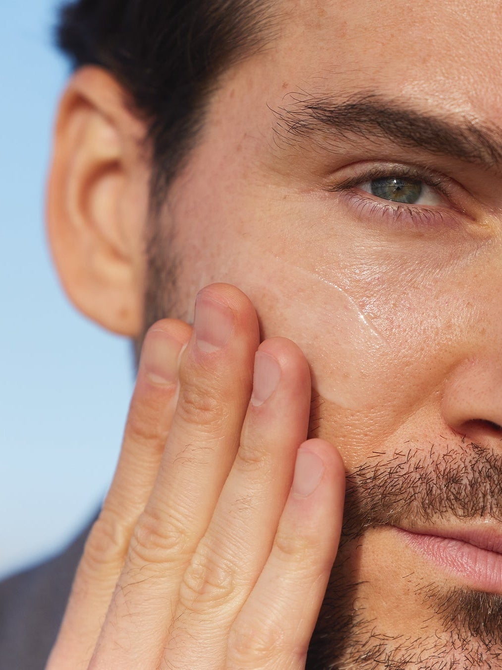 male putting moisturiser on his cheek
