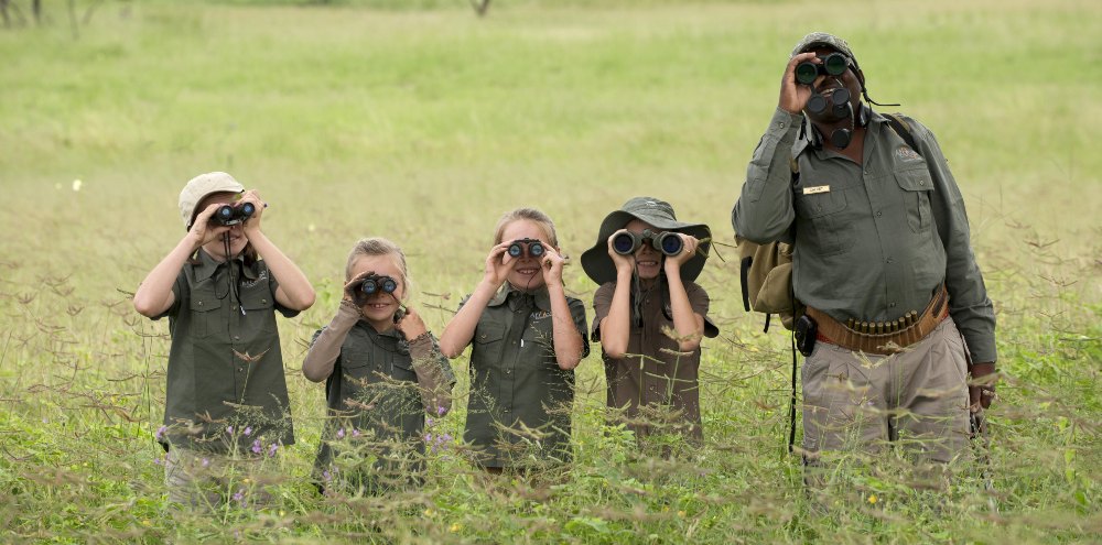 Children and a safari guide looking for wildlife during a walking safari