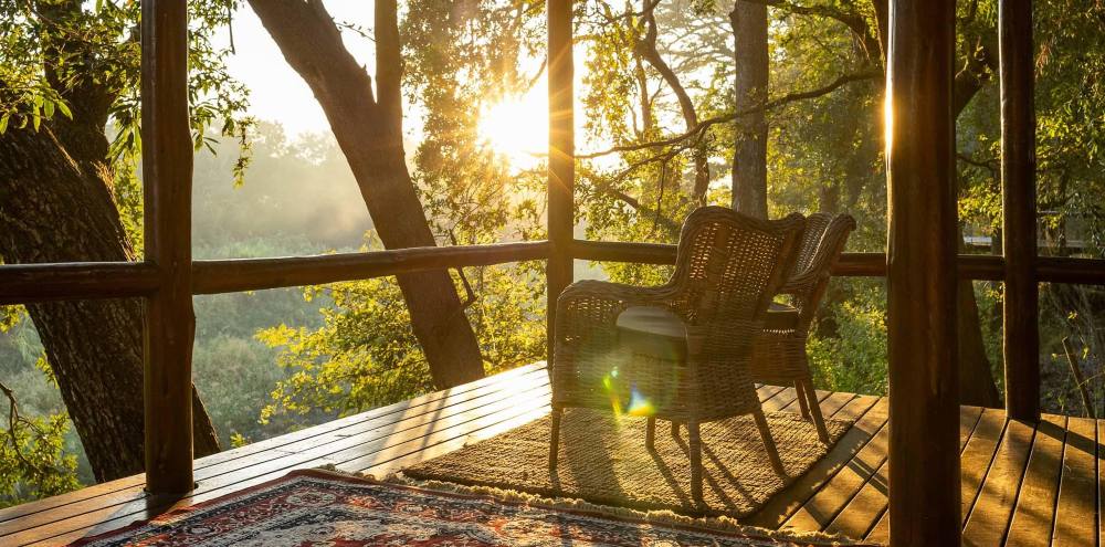 Sunlit deck overlooking the river at Karongwe River Lodge
