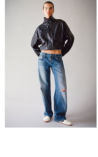Model wearing black leather jacket and distressed blue jeans