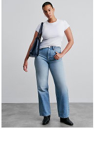 Woman wearing white t-shirt and blue jeans with black bag